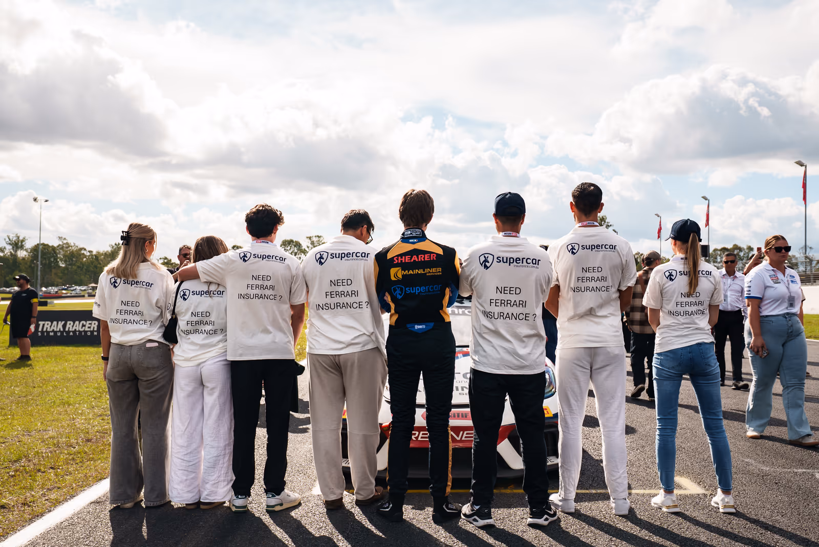 Supercar Insurance team members on the grid wearing 'Need Ferrari insurance?' shirts